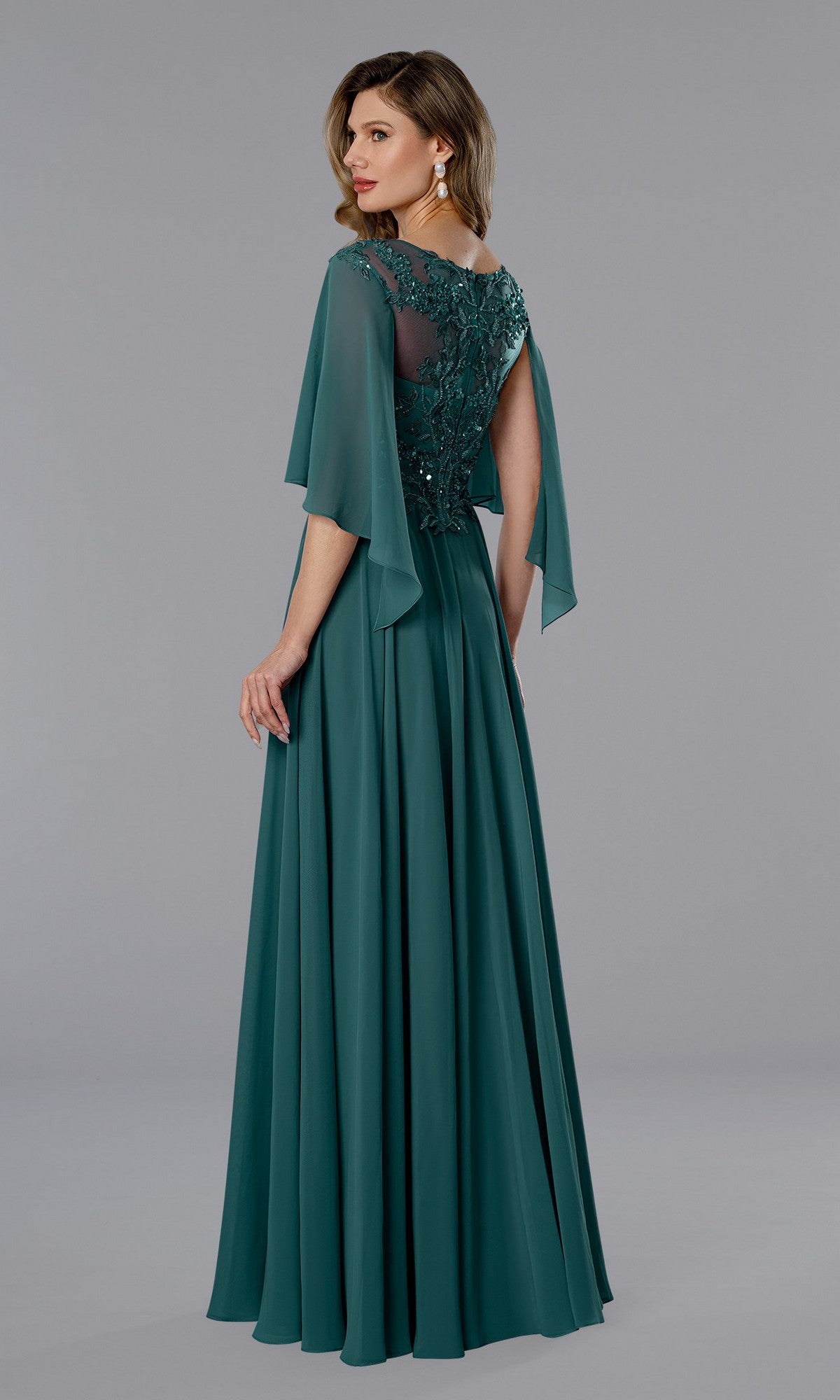 Woman wearing the Stella Couture 25351 long formal dress—teal chiffon with sheer sleeves, sequin lace bodice, and floral back details—posed against a plain gray background.